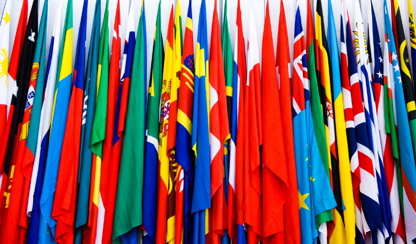 Multi-coloured flags in a row on white background