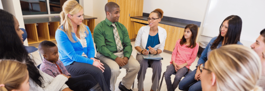 A group of teachers and students sit together in a circle