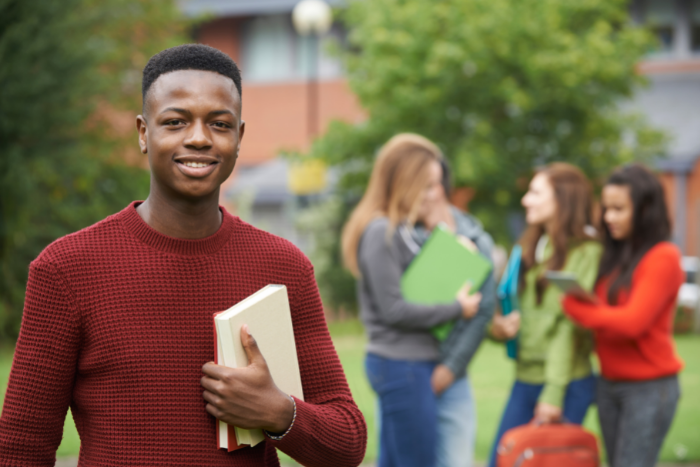 Young teen holding notepad, smiling